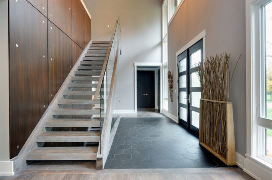 Cầu thang với tông màu trắng như trong thiết kế trong hình ảnh này phù hợp với mọi căn nhà, cửa sổ và cửa đi có nhiều ô kính giúp ánh sáng tràn vào ngôi nhà. Việc trang trí cũng tạo nên thành công cho mẫu thiết kế này. 